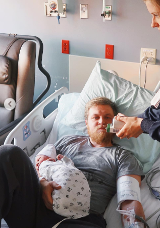 Andrew Goette holding infant son in the hospital.