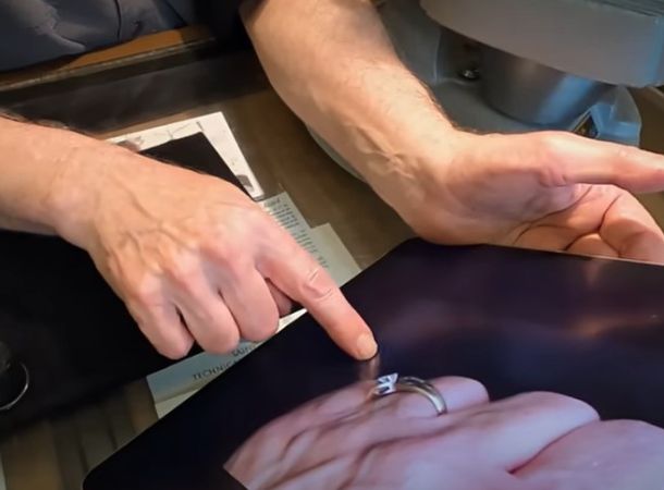 A jeweler studies a photo of the missing gold and diamond ring. 