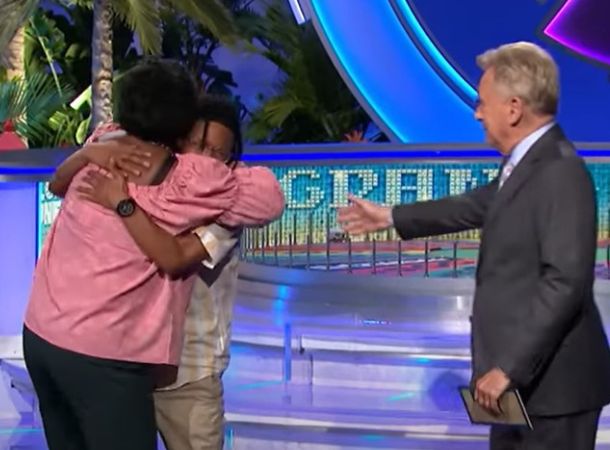 Retta Alexander hugs her grandson, Julian Hernandez, as Pat Sajak looks on