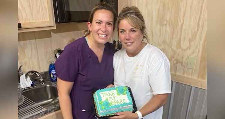 Rachel Harrelson and Julie Patterson holding cake that says "take my spare."