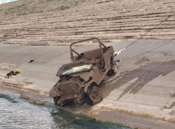 an old damaged jeep just pulled out of the water
