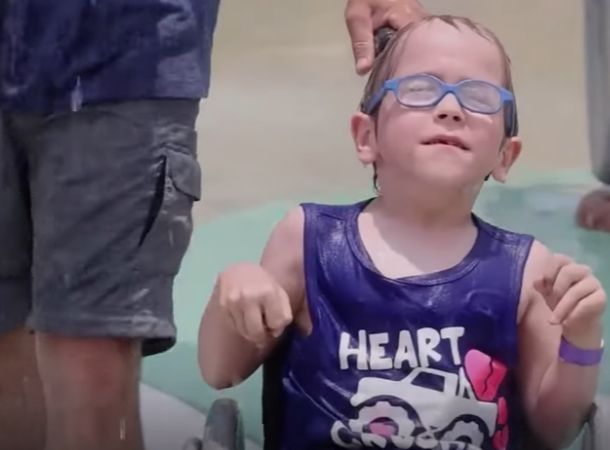 A child in a wheelchair enjoys the accessible waterpark.
