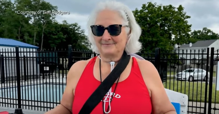 Gail Rodgers smiles in her lifeguard uniform and sunglasses.