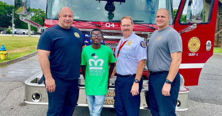 OT Hall poses with three Knoxville Fire Department firefighters who helped deliver him as a baby.