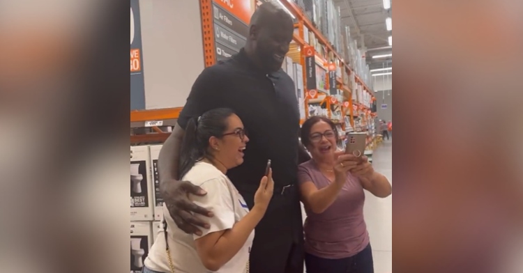 Shaquille O'Neal smiles as he poses for selfies with a Mom and daughter he just surprised at Home Depot.