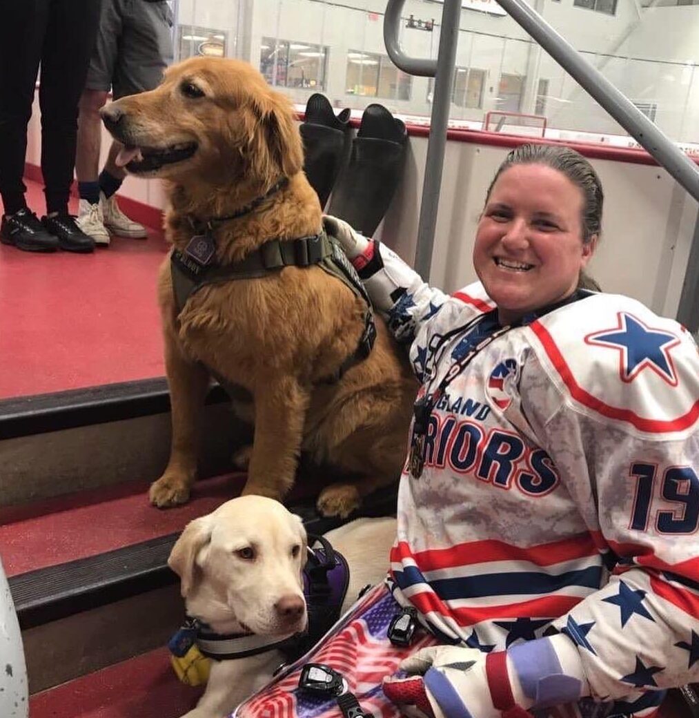Christy Harding in hockey gear with her two dogs Doug and Moxie.