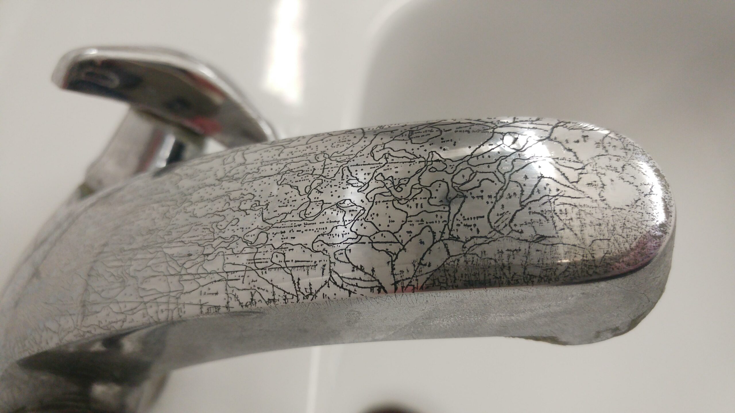 corrosion on a faucet that looks like a map