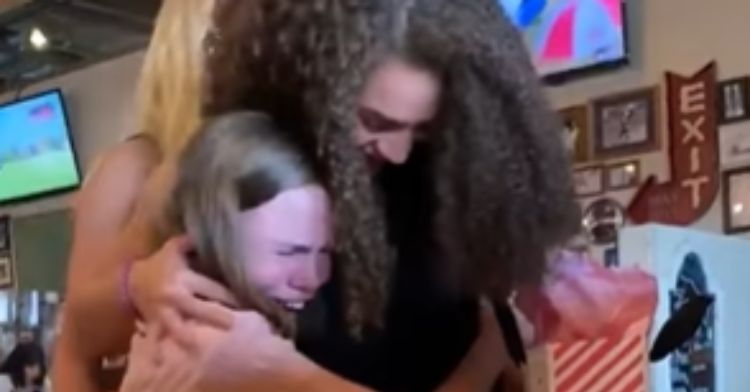 Two best friends hugging after a surprise visit.