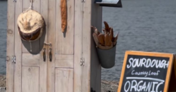 This baker leaves his bread in a cabinet for customers to find.