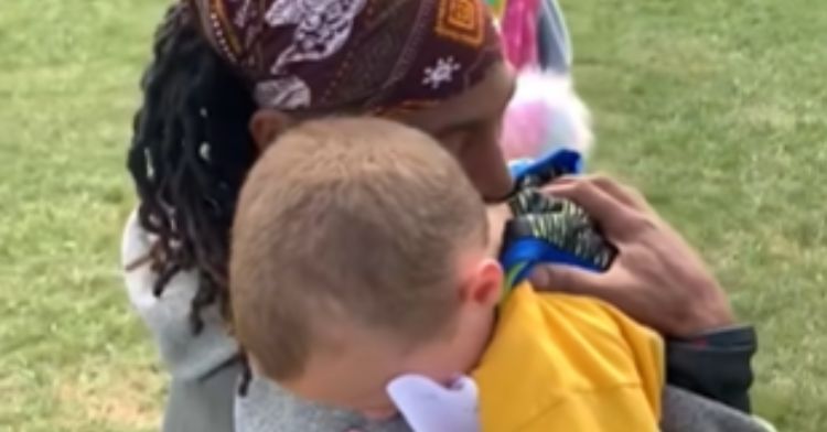 A little boy hugs his favorite football coach.