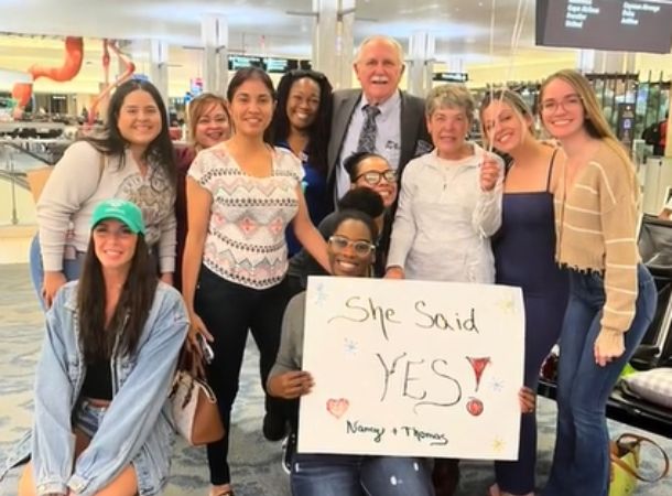 Thomas and his coworkers pose with Nancy after she said yes.