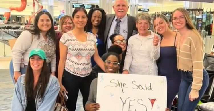 Thomas and his coworkers pose with Nancy after she said yes.