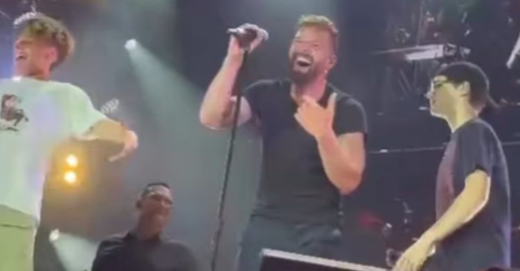 Ricky Martin beams as his sons dance with him on stage.