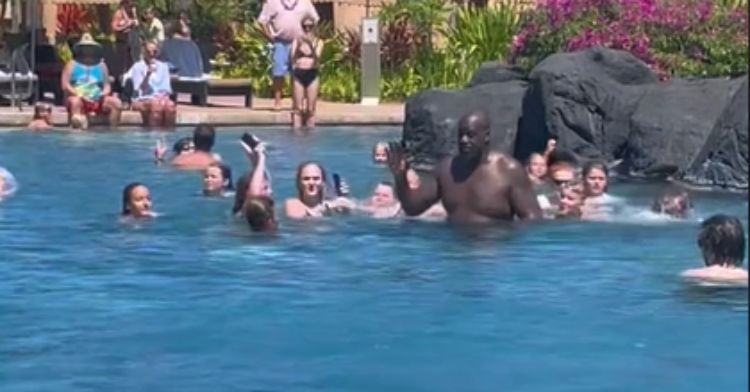 Shaq high-fives young fans at the pool.