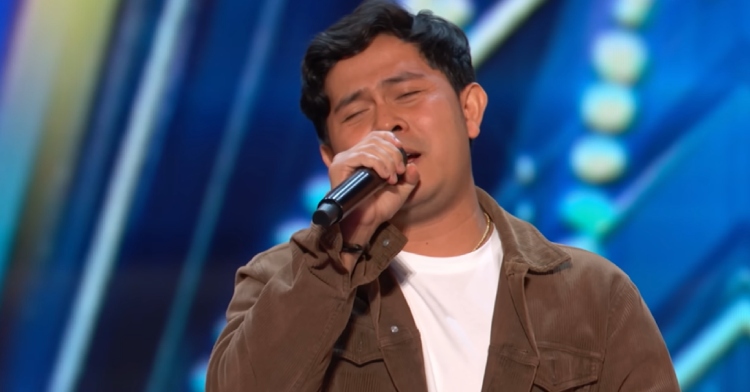 Cakra Khan sings on the "AGT" stage with his eyes closed.