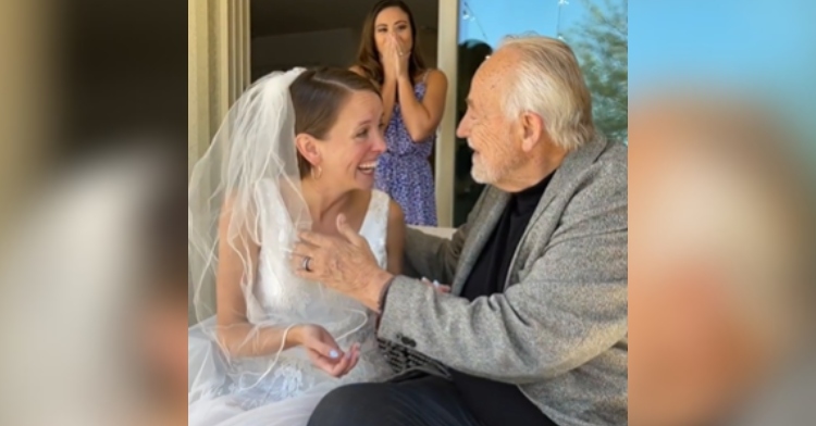 A bride smiles, on the verge of tears, as her dad with dementia sits next to her and remembers her.