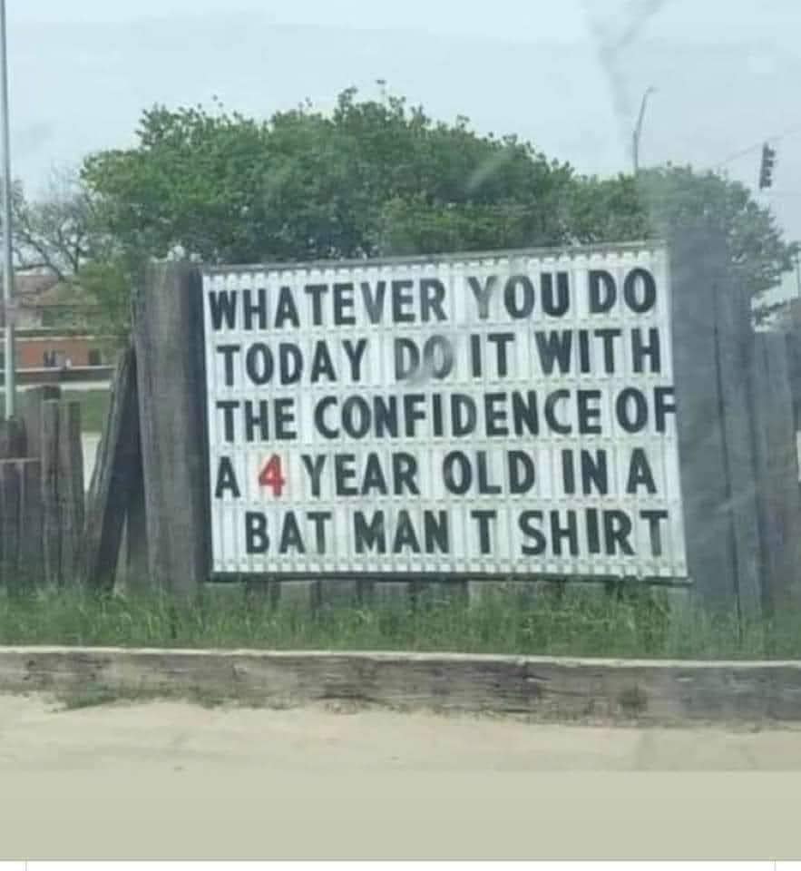 Roadside sign that reads "Whatever you do today do it with the confidence of a 4 year old in a Batman t shirt."
