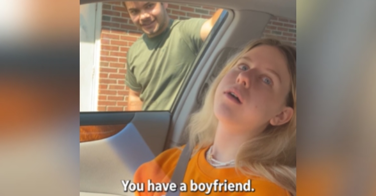 A blonde young woman leans back in the car, mouth agape. She just had her wisdom teeth removed. A young man stands outside her window. Text on the image reads “You have a boyfriend.”
