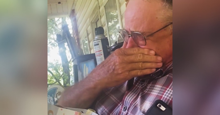 Close up of an older man crying as he covers his mouth and nose with his hand.