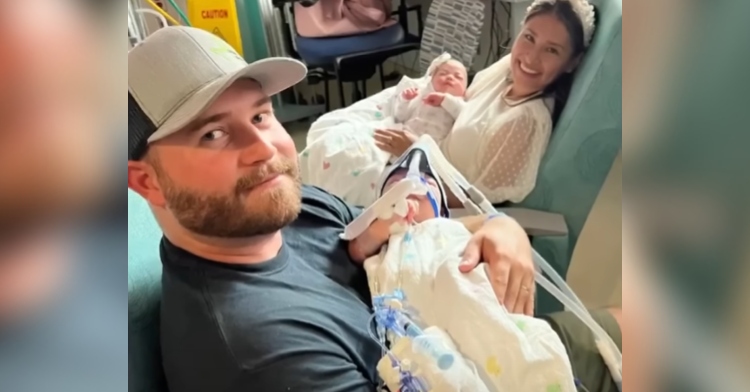 Jesse and Sandy Fuller smile as they sit and hold their twins separately.