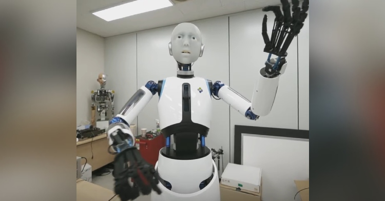 Front-facing view of the completed EverR 6 robot with its arms and hands in the position of a conductor. The robot has a face, arms, torso, and hands resembling a human's.