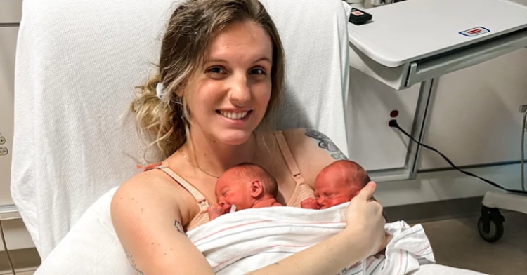 Meghan Huston smiles wide as she sits in a hospital bed, holding both of her twins, Declan and River.