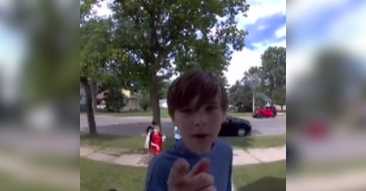 Young kids points to a security camera as he talks to the person who lives at the home.