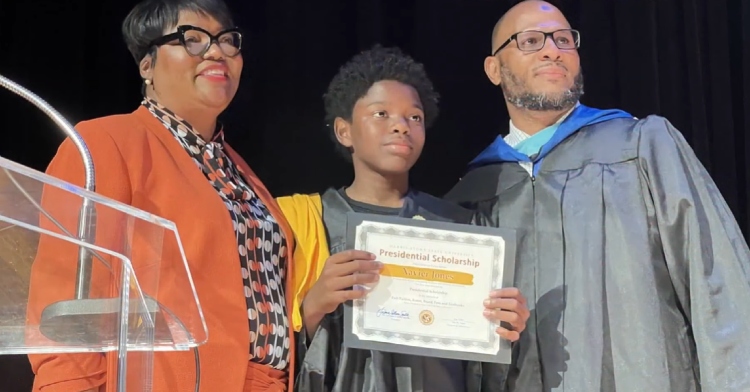 Collins Smith, Xavier Jones, and a man smile as they pose together, Xavier holding up his scholarship.