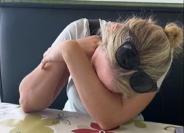 An embarrassed mom laughing after she accidently created a hilarious wedding album.