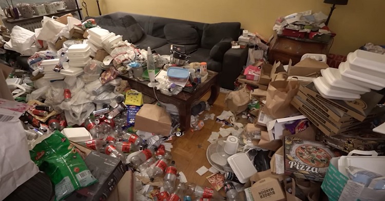 Image shows a living room in complete disarray with trash and other debris strewn everywhere.