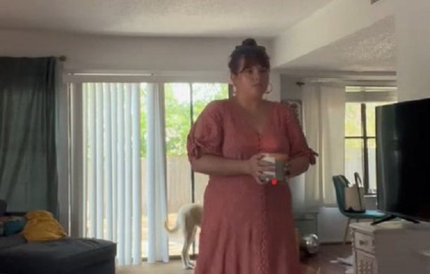 Image shows a female performing a ritual out of habit, carrying a lit candle from one location to another.