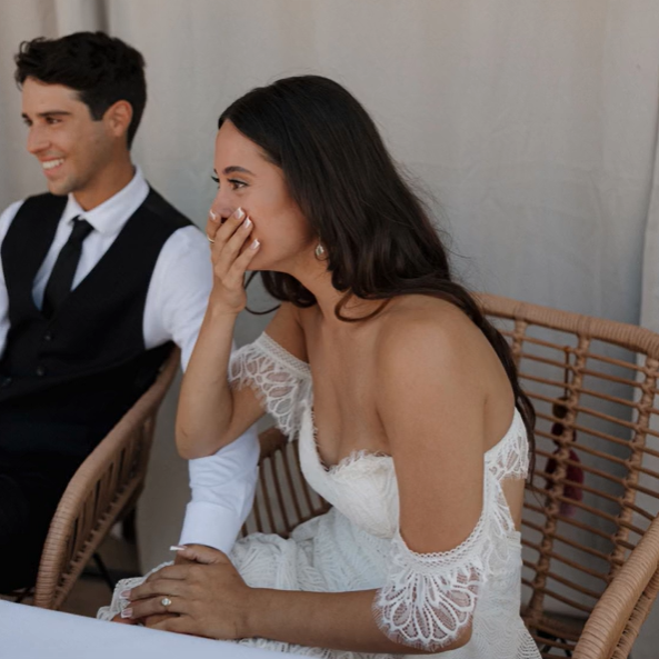 Bride contains her joy while watching her parents' first dance.