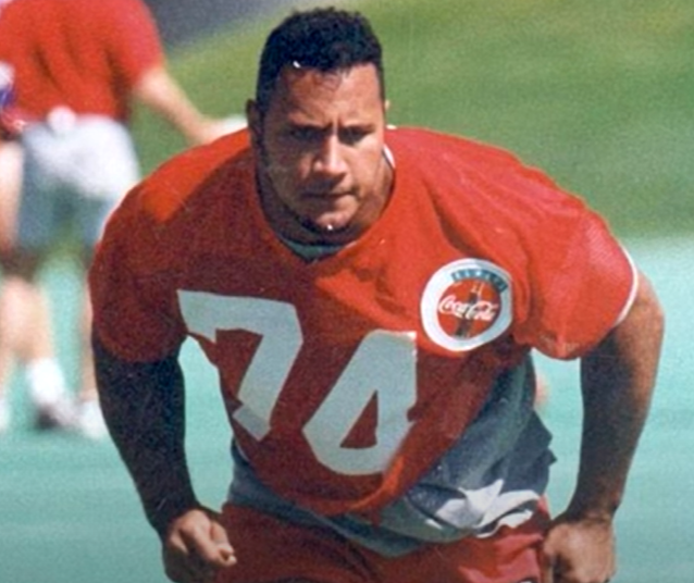 Dwayne 'The Rock' Johnson at Age 20 with football jersey.