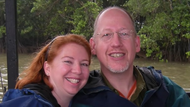 Tanya and Mike, a couple in love, posing on a boat cruising along an unknown river.