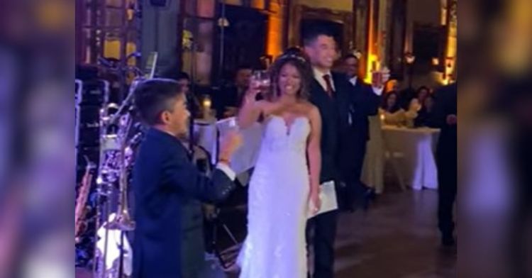 Image shows a wedding couple and son offering a toast.