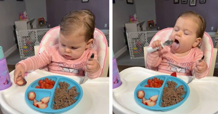 a baby trying and failing to put a strawberry into her mouth