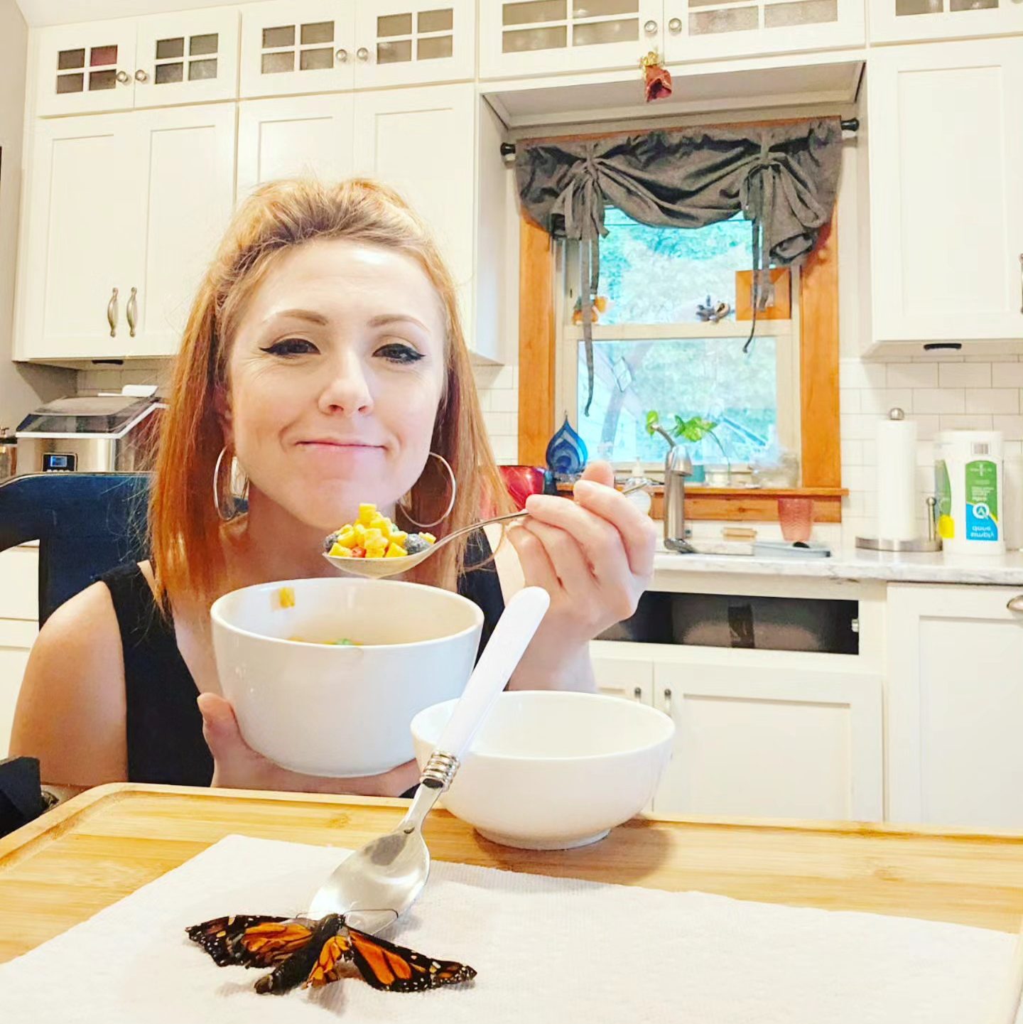 Woman eats breakfast with a butterfly.