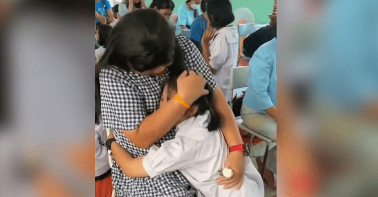 father wearing dress hugs daughter