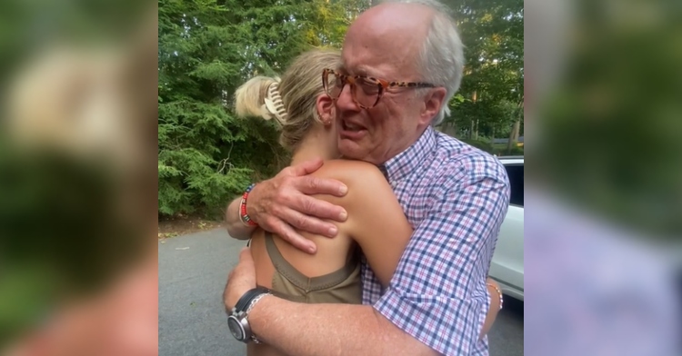 A man and his daughter hug. The daughter’s face can’t be seen but dad can be seen in tears.