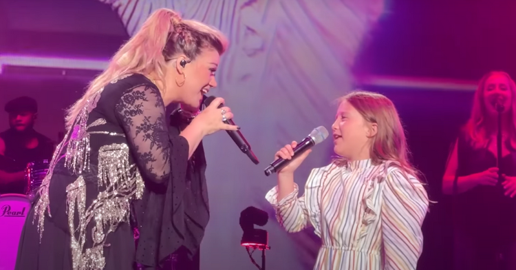Kelly Clarkson and daughter on stage.