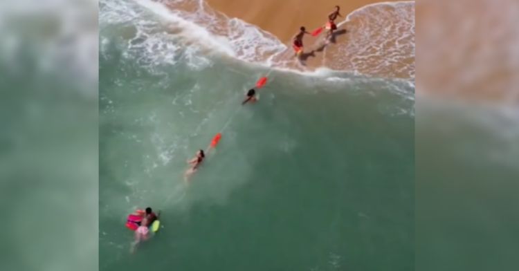 The lifeguards formed a human chain to pull the swimmer to shore.