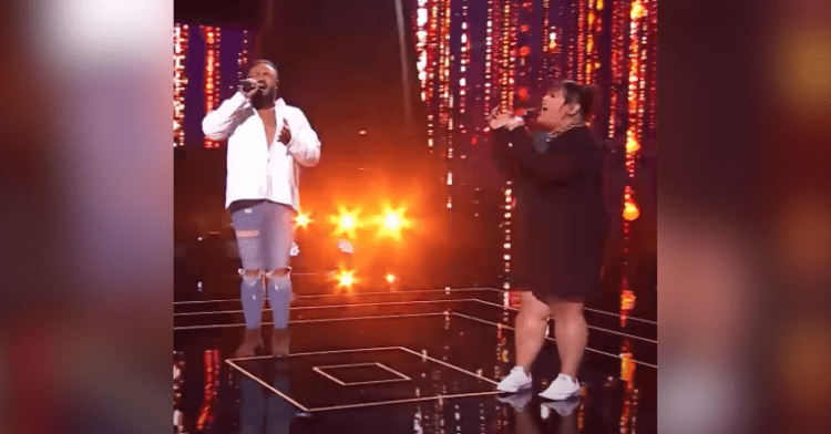 man and woman sing on stage with lights