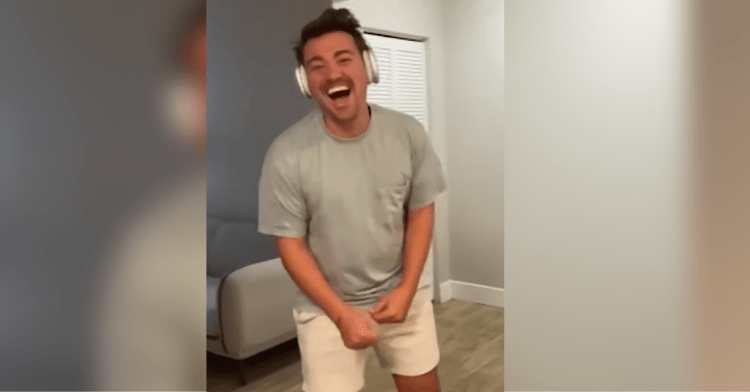 Man laughing after unwrapping his birthday gift.