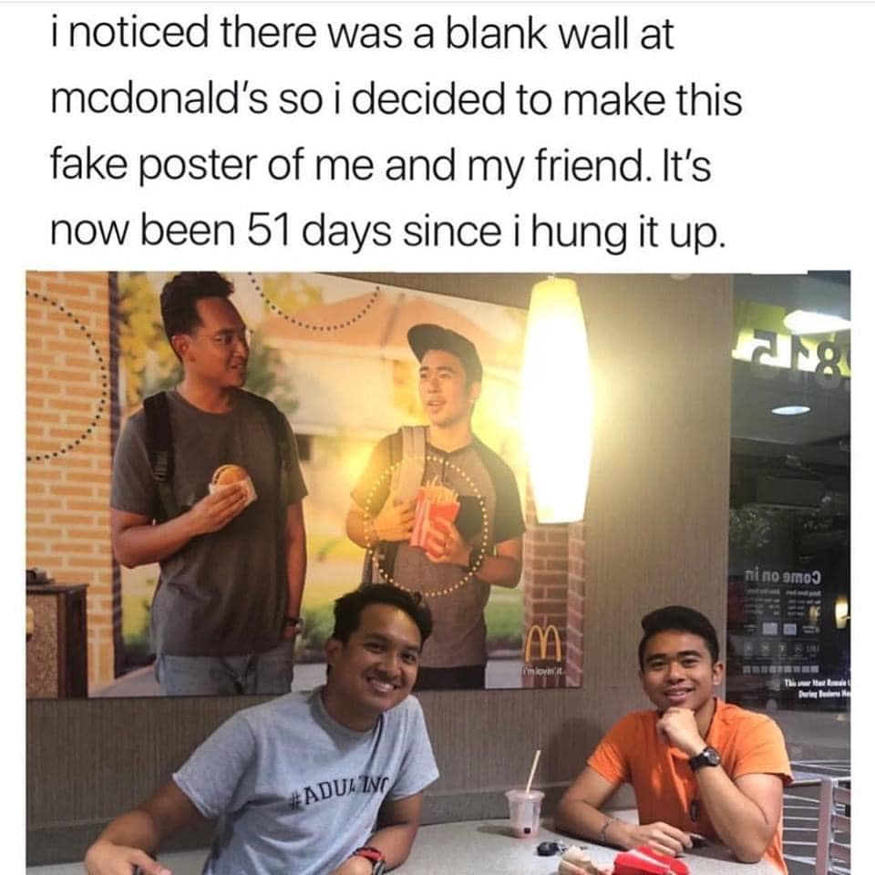 men hanging photo of themselves in restaurant
