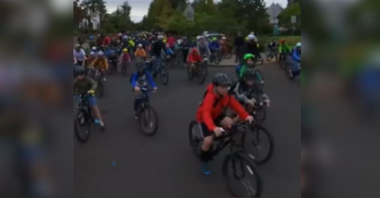 A P.E. teacher and his students ride their bikes to school.