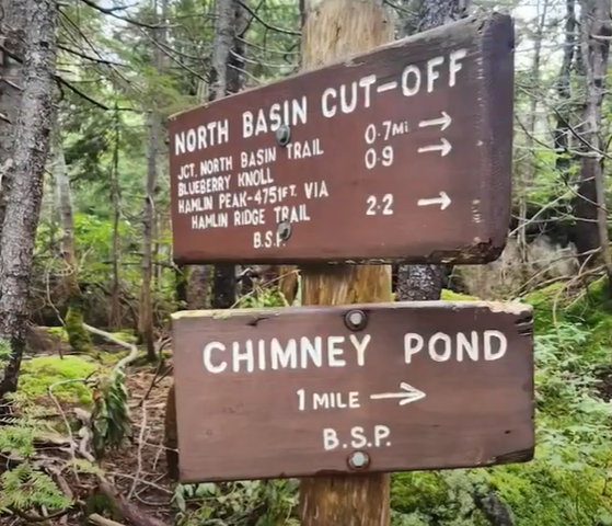 two signs for trailheads and distances