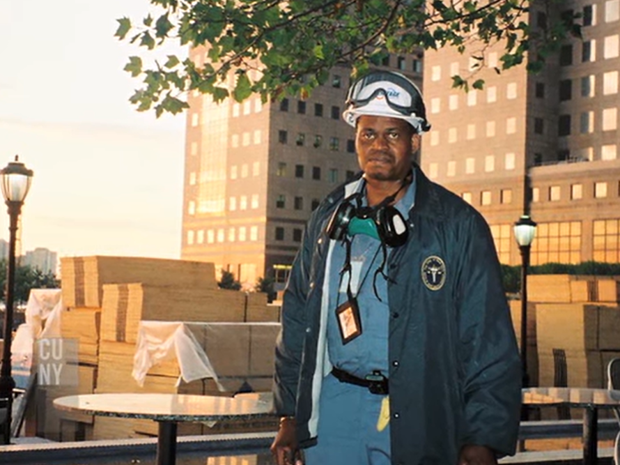 Darryl Warner, dressed in scrubs, looking exhausted as he stands outside.