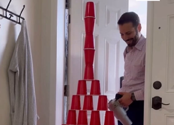 A Dad opening the front door to find a pyramid of Solo plastic cups set up by his sons as a prank.
