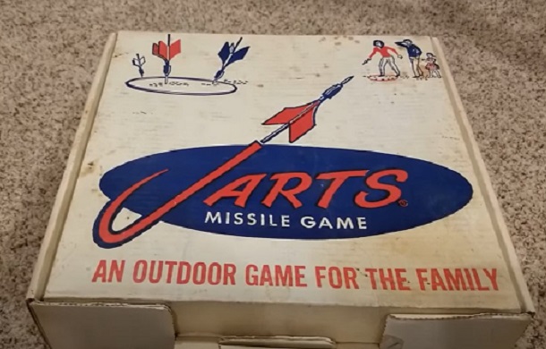 Image shows a vintage box containing a set of Jarts, the lawn dart game banned in the 1980s as a dangerous toy.