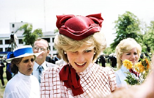 Image show Princess Diana in a bright red hat and white suit while visiting Halifax.